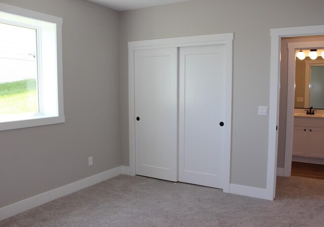 4651 180th St, Urbandale, IA 50323 - unfurnished bedroom featuring light carpet and a closet