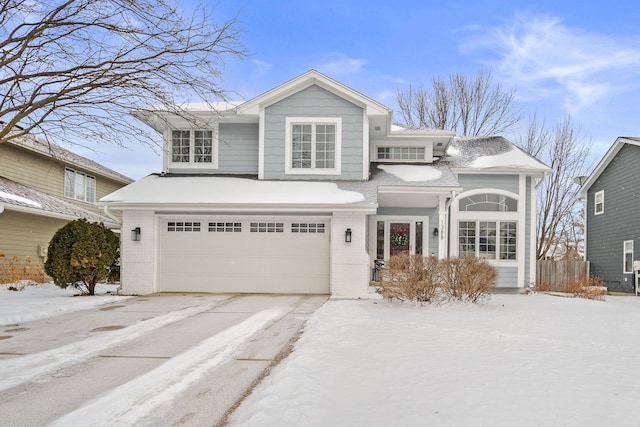 traditional-style house with a garage, brick siding, and fence