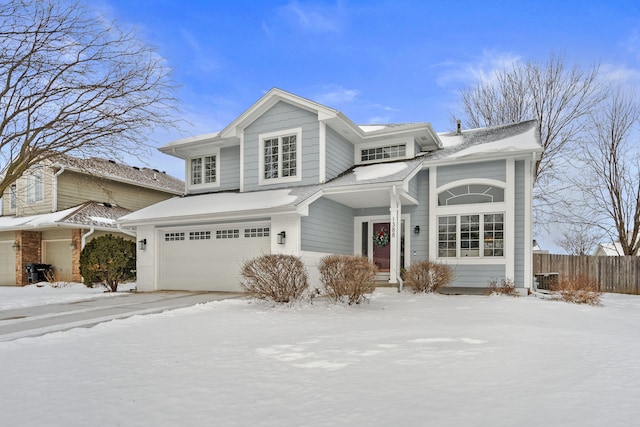 traditional-style home with a garage and fence