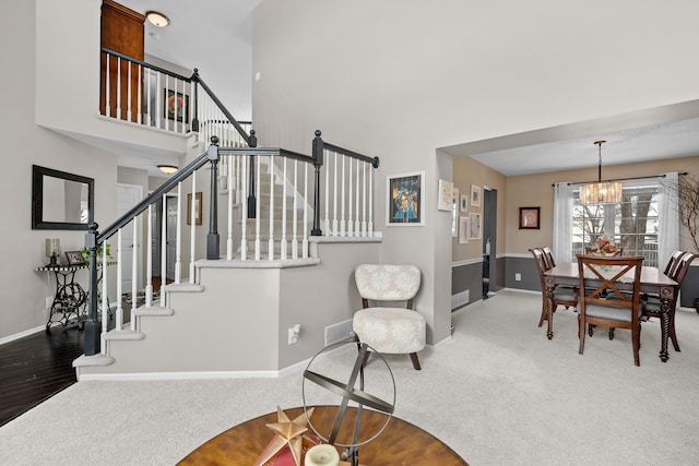 interior space featuring carpet, a high ceiling, and an inviting chandelier