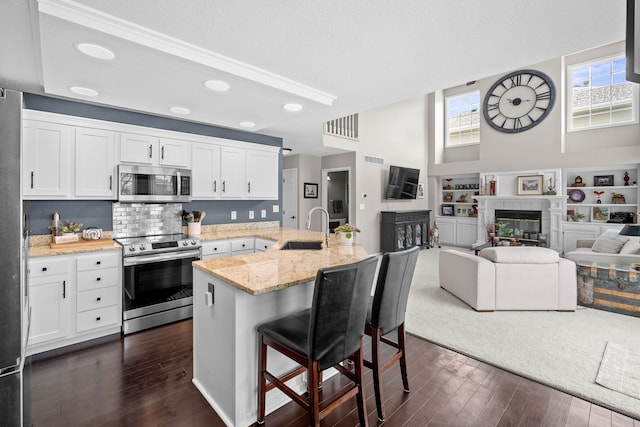 kitchen featuring sink, appliances with stainless steel finishes, white cabinetry, and a breakfast bar