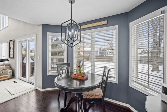 dining space with a chandelier and dark hardwood / wood-style flooring