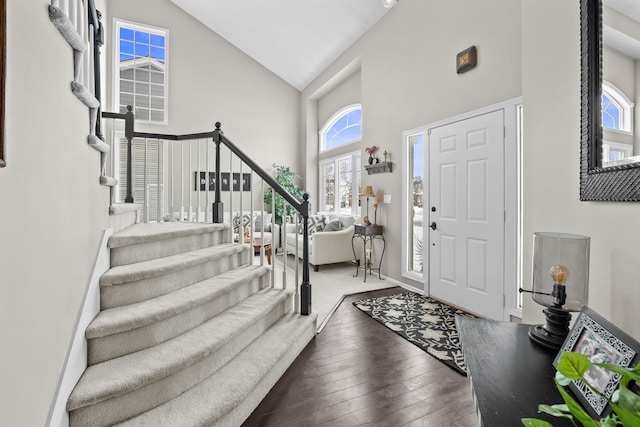 entryway featuring dark wood-type flooring and high vaulted ceiling