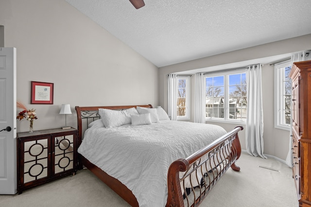 bedroom with ceiling fan, light carpet, a textured ceiling, and lofted ceiling