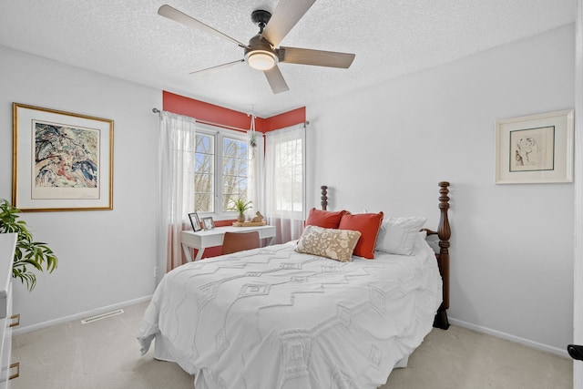 bedroom featuring a textured ceiling, ceiling fan, and light colored carpet