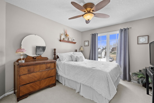 carpeted bedroom with a textured ceiling and ceiling fan