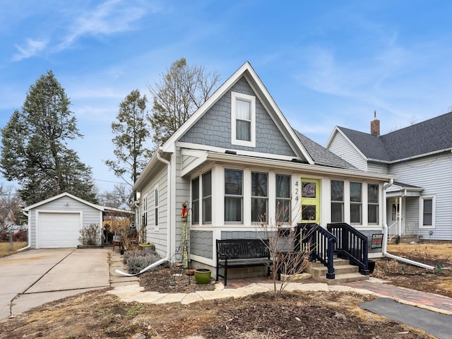 view of front facade with driveway, a detached garage, and an outdoor structure