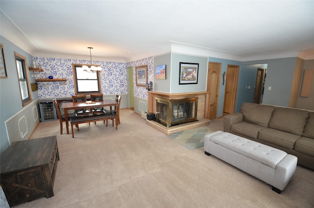 living room featuring light carpet, a multi sided fireplace, an inviting chandelier, and ornamental molding