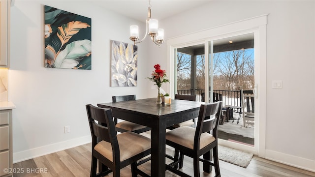 dining space featuring light wood-style floors, a chandelier, and baseboards