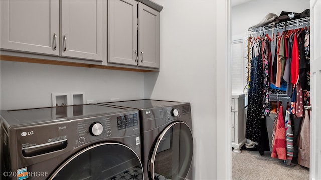 laundry room with cabinet space, washer and dryer, and light colored carpet