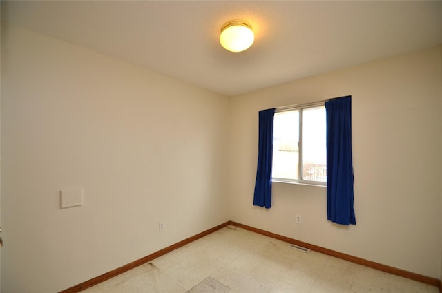 empty room featuring visible vents, baseboards, and tile patterned floors