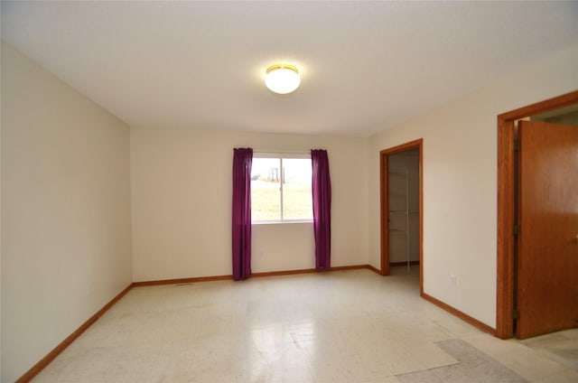 empty room featuring light floors and baseboards