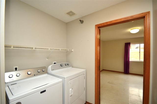 washroom with laundry area, baseboards, visible vents, washing machine and clothes dryer, and light floors