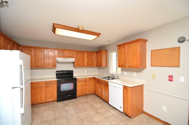 kitchen with brown cabinets, light countertops, a sink, white appliances, and under cabinet range hood