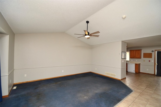 unfurnished living room featuring ceiling fan, light tile patterned flooring, visible vents, baseboards, and vaulted ceiling