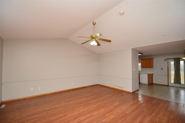 unfurnished living room featuring baseboards, visible vents, dark wood finished floors, a ceiling fan, and lofted ceiling