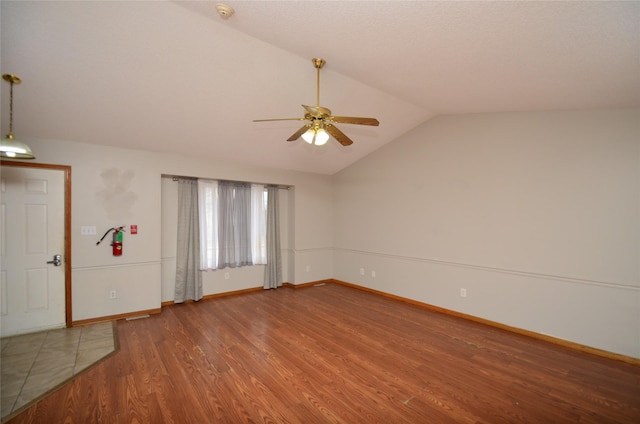 interior space featuring lofted ceiling, wood finished floors, a ceiling fan, and baseboards