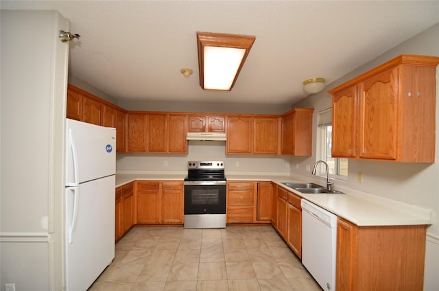 kitchen featuring white appliances, brown cabinets, light countertops, under cabinet range hood, and a sink