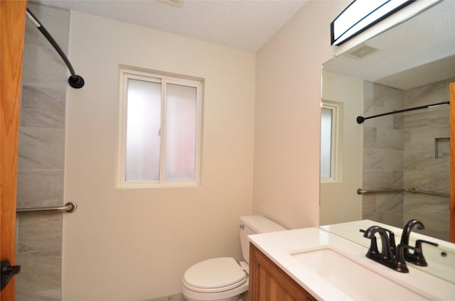 full bath with toilet, a textured ceiling, vanity, and visible vents