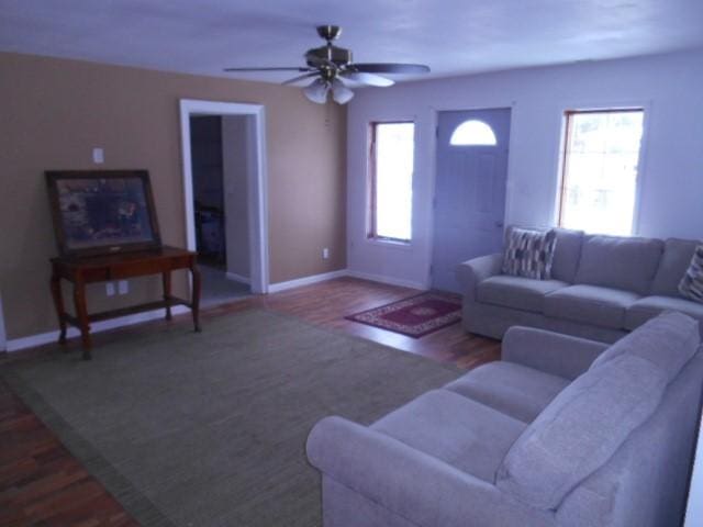 living room featuring ceiling fan and dark hardwood / wood-style floors