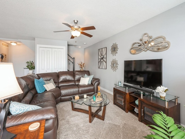 carpeted living room with a textured ceiling and ceiling fan