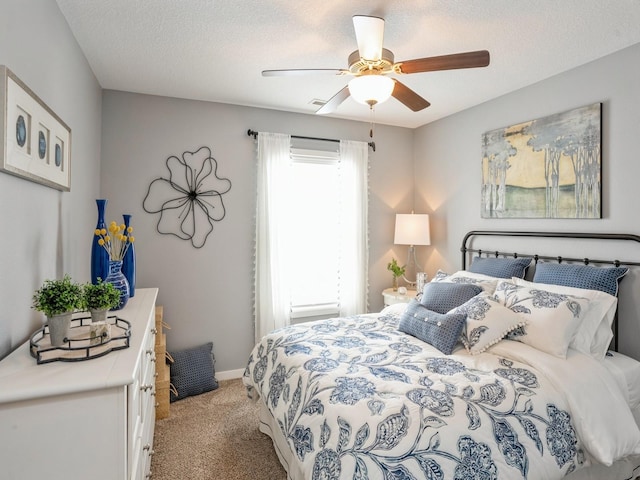 carpeted bedroom featuring a textured ceiling and ceiling fan