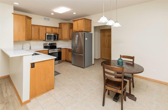 kitchen with stainless steel appliances, decorative light fixtures, light tile patterned floors, sink, and kitchen peninsula