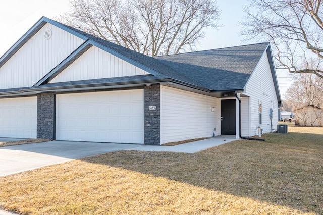 view of front of home featuring an attached garage, a shingled roof, central AC, and concrete driveway