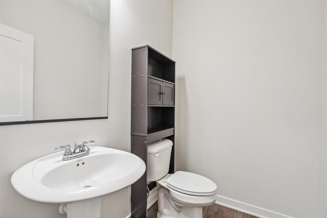 bathroom featuring hardwood / wood-style flooring, sink, and toilet