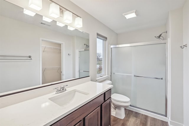 bathroom with toilet, vanity, an enclosed shower, and wood-type flooring