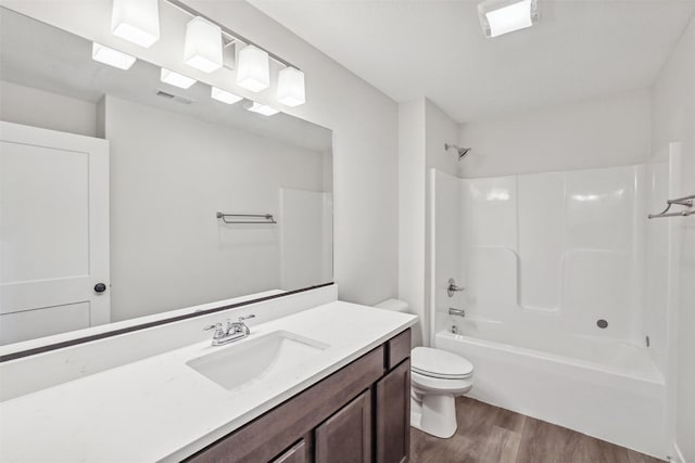 full bathroom featuring hardwood / wood-style floors, bathing tub / shower combination, vanity, and toilet