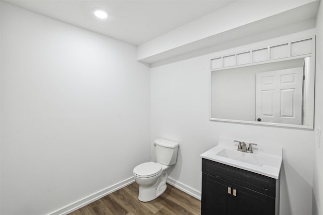 bathroom with wood-type flooring, vanity, and toilet