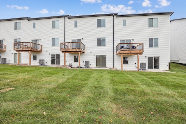 back of property with cooling unit and a lawn