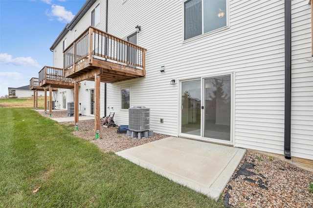 back of property featuring a deck, a patio, cooling unit, and a yard