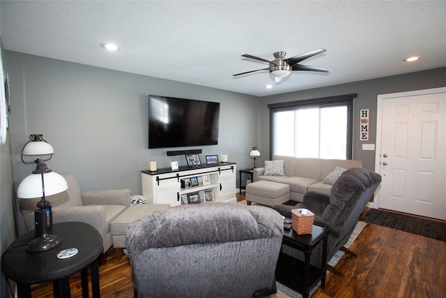 living room with ceiling fan, a textured ceiling, and dark hardwood / wood-style flooring