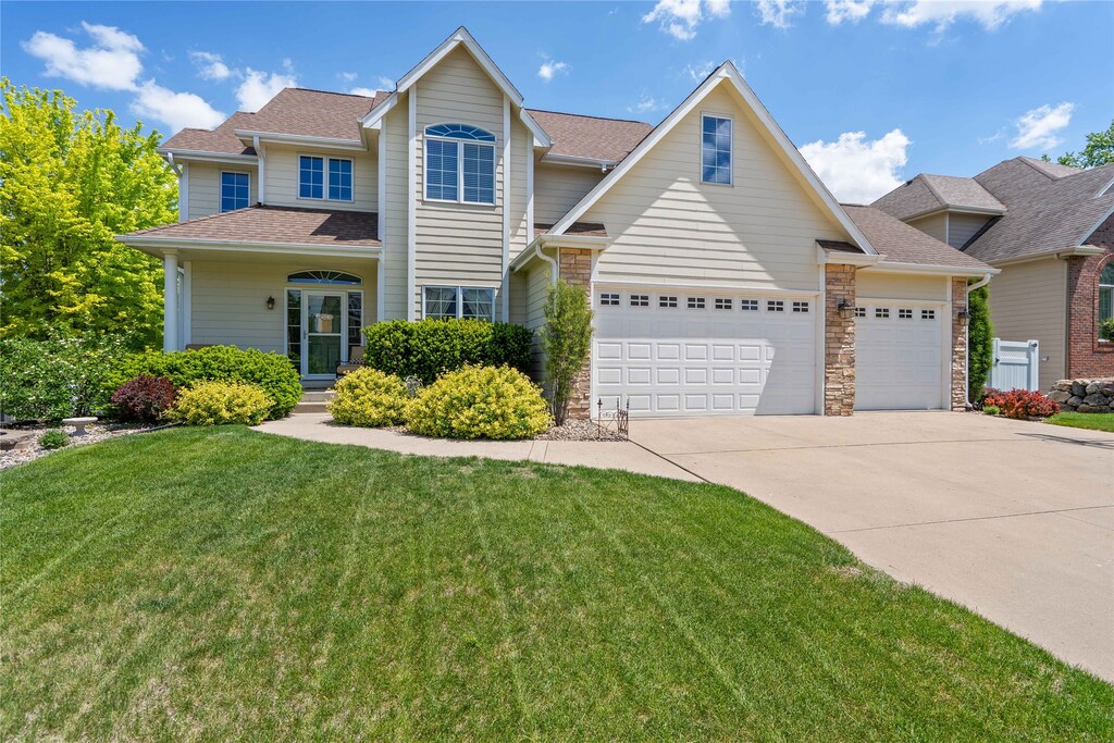 2639 NW 160th St, Clive, IA 50325 - traditional-style house featuring an attached garage, driveway, a front yard, and roof with shingles
