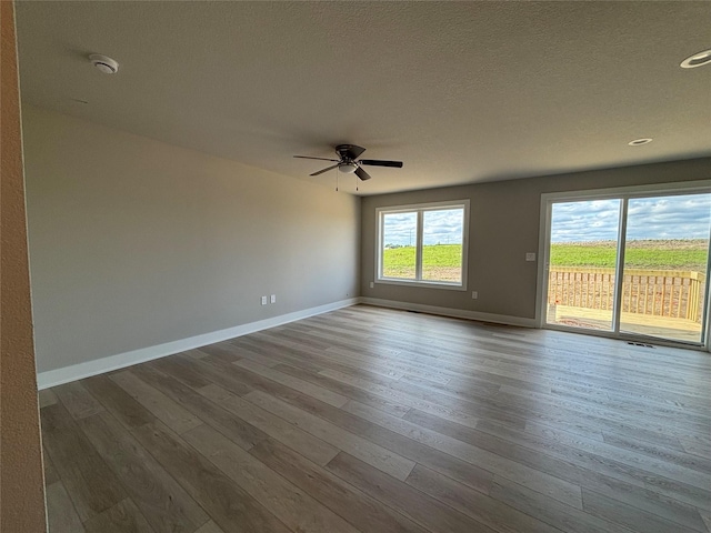 1715 Gordon Ct, Norwalk, IA 50211 - spare room featuring a smoke detector, a ceiling fan, baseboards, wood finished floors, and a textured ceiling