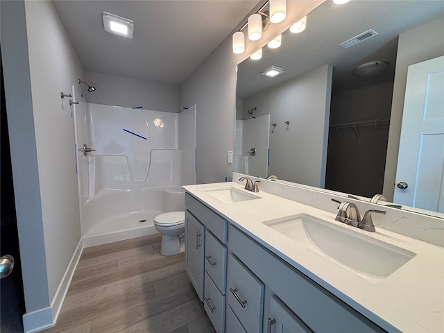 1715 Gordon Ct, Norwalk, IA 50211 - full bathroom with a shower, wood finished floors, toilet, and double vanity