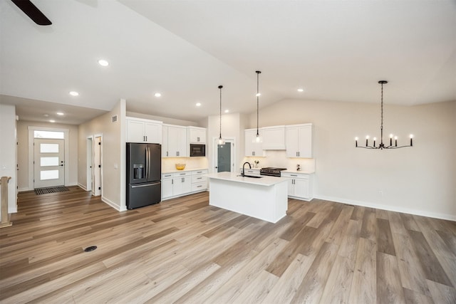 18258 Hidden Knl, Clive, IA 50325 - kitchen with black appliances, a sink, vaulted ceiling, a center island with sink, and light countertops