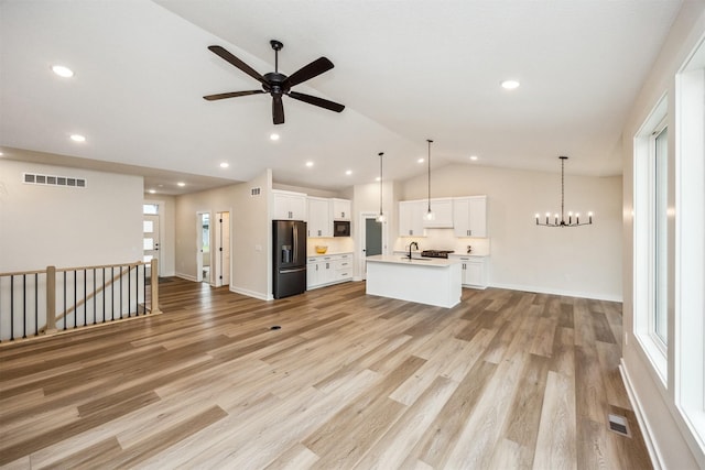 18258 Hidden Knl, Clive, IA 50325 - unfurnished living room featuring a sink, lofted ceiling, a ceiling fan, light wood finished floors, and a chandelier