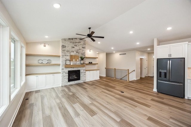 18258 Hidden Knl, Clive, IA 50325 - unfurnished living room with light wood-type flooring, a ceiling fan, vaulted ceiling, a fireplace, and recessed lighting
