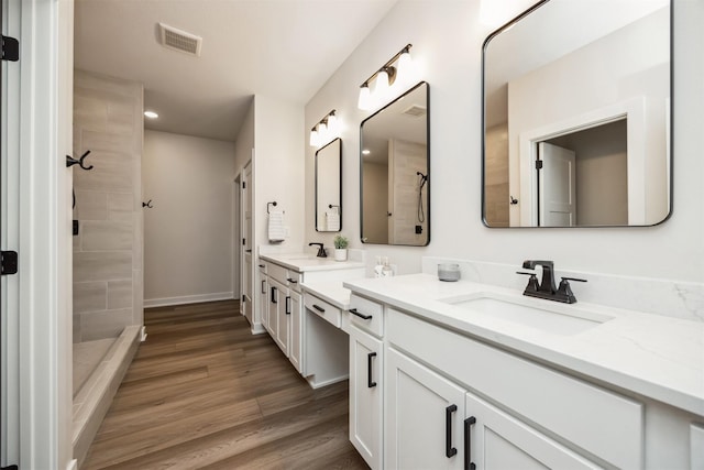 18258 Hidden Knl, Clive, IA 50325 - bathroom featuring tiled shower, double vanity, wood finished floors, recessed lighting, and baseboards