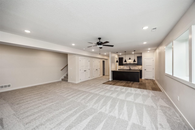 18258 Hidden Knl, Clive, IA 50325 - unfurnished living room featuring light carpet, recessed lighting, stairs, baseboards, and ceiling fan