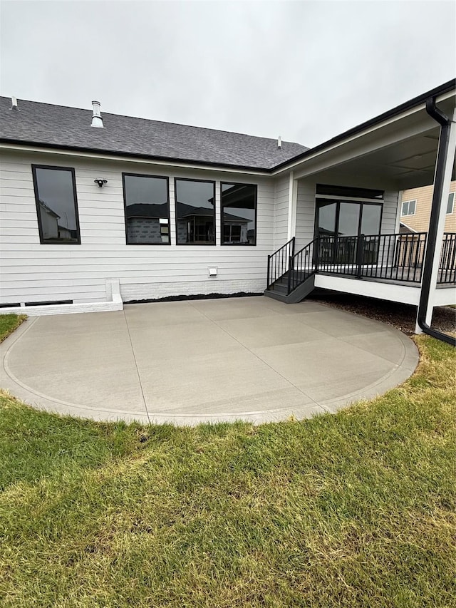 18258 Hidden Knl, Clive, IA 50325 - rear view of house with a patio area, a lawn, and a shingled roof