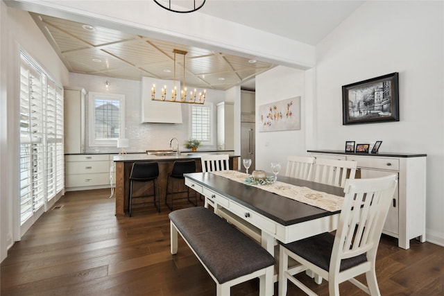 dining space featuring an inviting chandelier, dark hardwood / wood-style flooring, wooden ceiling, and sink