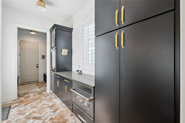 kitchen featuring gray cabinets, stainless steel oven, and built in refrigerator