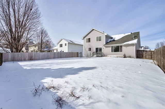 view of snow covered back of property