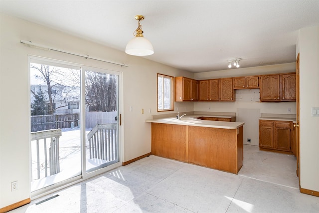 kitchen with sink, pendant lighting, and kitchen peninsula