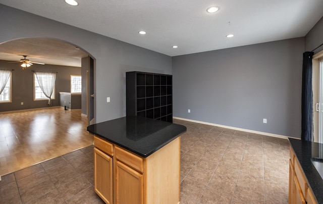 kitchen featuring ceiling fan, tile patterned floors, and a kitchen island