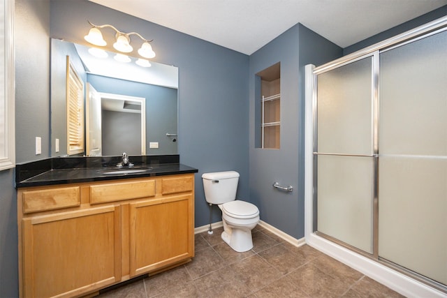 bathroom featuring tile patterned floors, toilet, vanity, and walk in shower